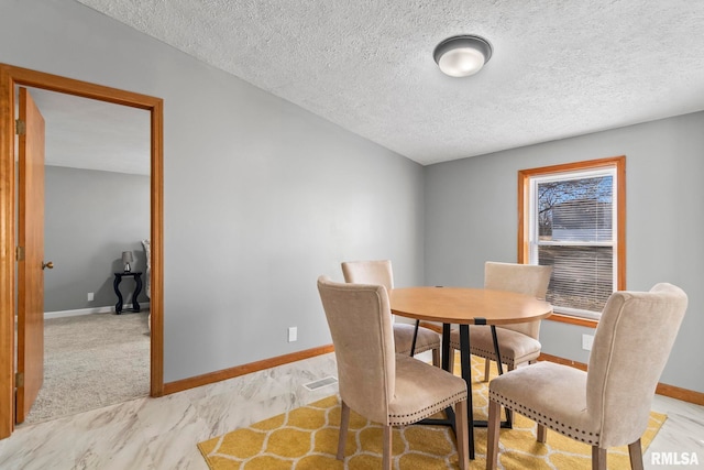 dining area with a textured ceiling and baseboards