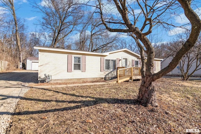 manufactured / mobile home with gravel driveway and an outdoor structure