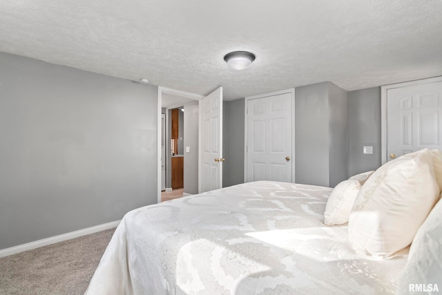 carpeted bedroom with a textured ceiling and baseboards