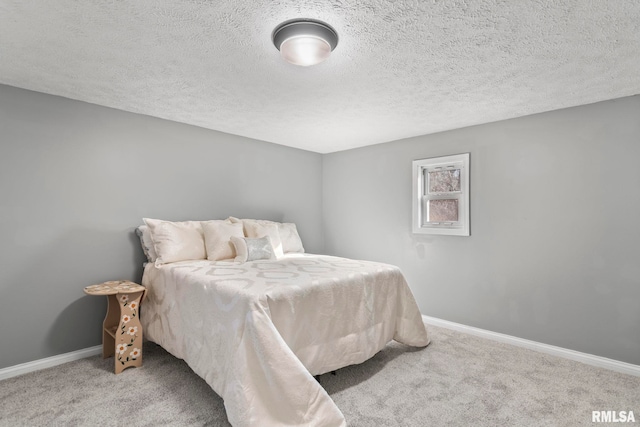 bedroom featuring a textured ceiling, carpet flooring, and baseboards