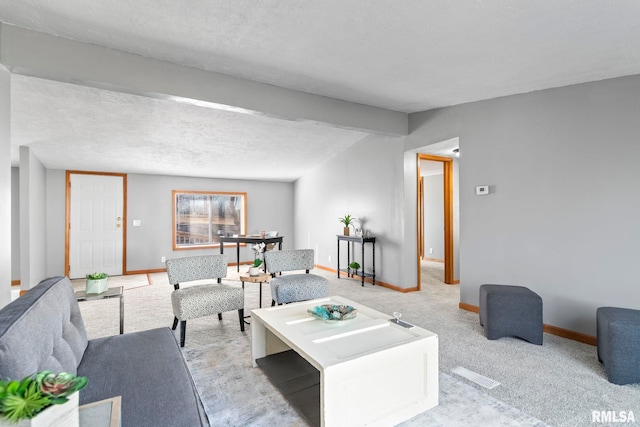 living area with a textured ceiling, carpet floors, and baseboards
