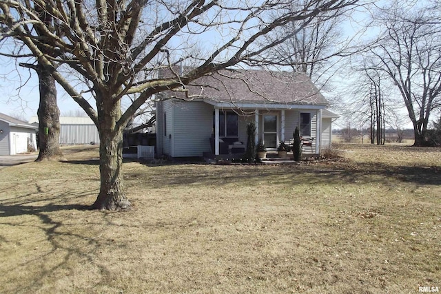 exterior space featuring a porch, roof with shingles, and a front yard