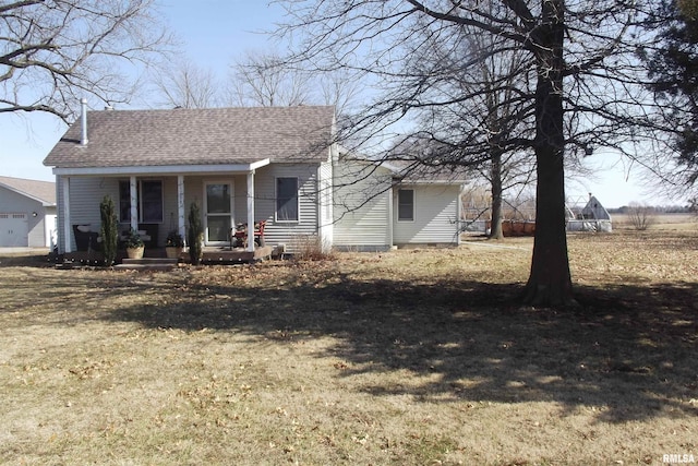 bungalow-style home with covered porch, a shingled roof, and a front yard