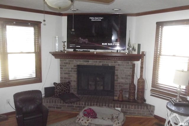 living area with crown molding, a wealth of natural light, and wood finished floors