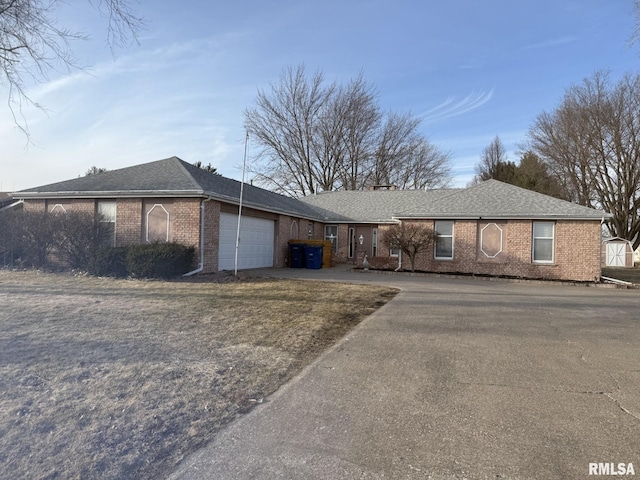 ranch-style house with concrete driveway, brick siding, roof with shingles, and an attached garage