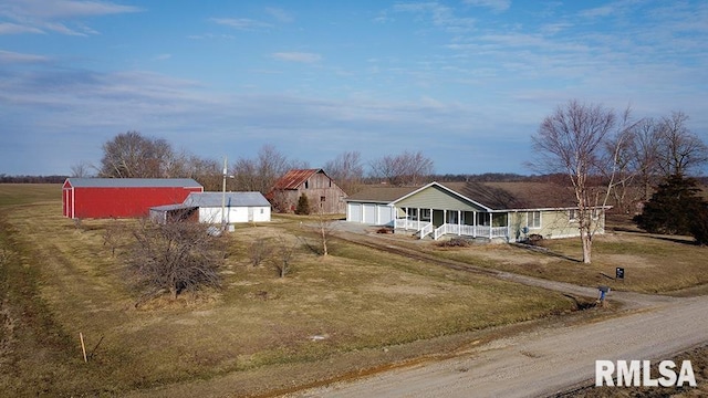 view of front facade featuring a front lawn, a porch, and an outbuilding