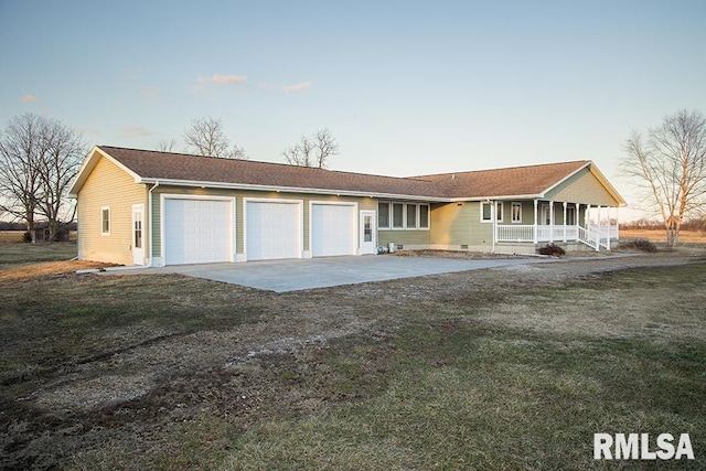 ranch-style home with covered porch, concrete driveway, a front lawn, and an attached garage