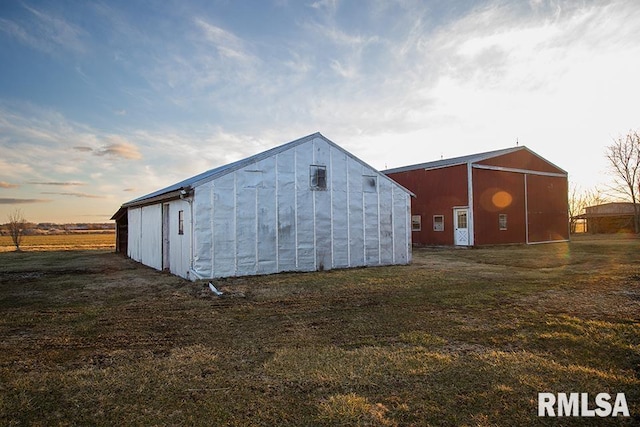 outdoor structure at dusk with a yard, an outbuilding, and an outdoor structure