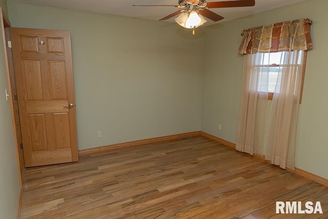 empty room with baseboards, a ceiling fan, and wood finished floors