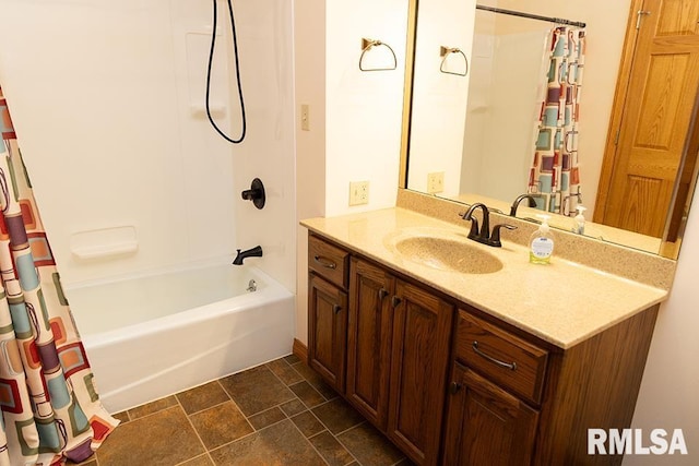 full bath featuring shower / bath combo, stone finish floor, and vanity