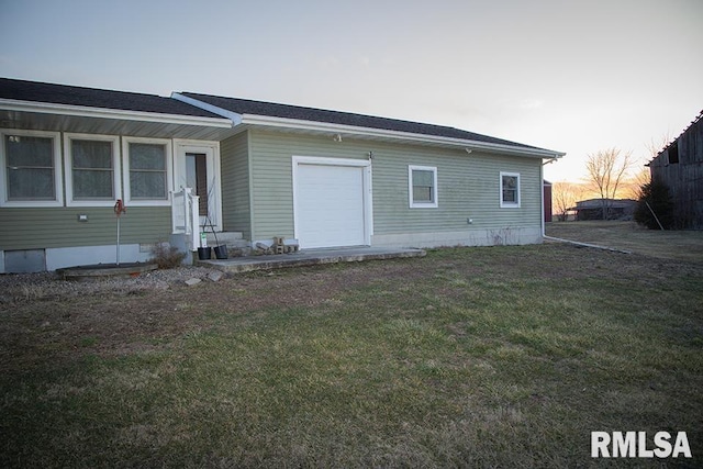 back of property at dusk featuring crawl space and a lawn