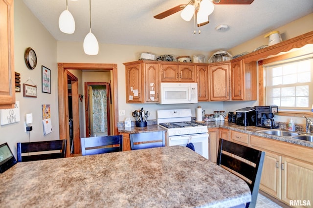 kitchen featuring white appliances, ceiling fan, light countertops, pendant lighting, and a sink