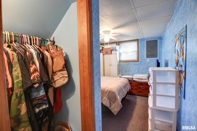 carpeted bedroom with electric panel and a drop ceiling