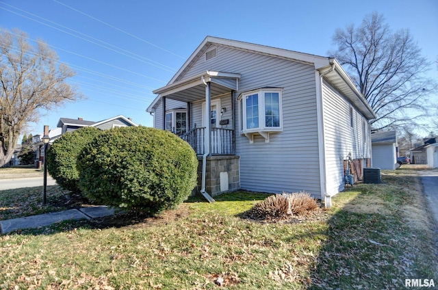 bungalow with central AC unit and a front yard