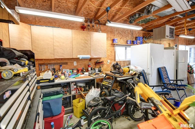 garage featuring a workshop area and freestanding refrigerator