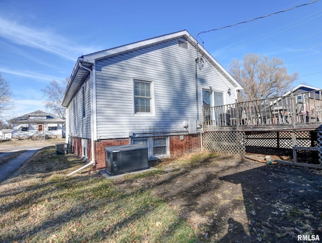 back of property with a deck and central AC