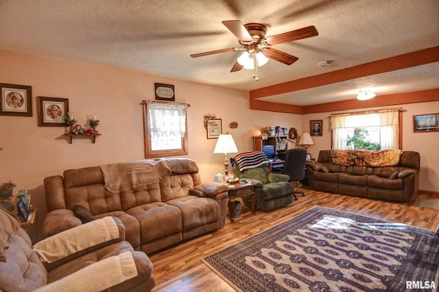 living room featuring a textured ceiling, ceiling fan, and wood finished floors