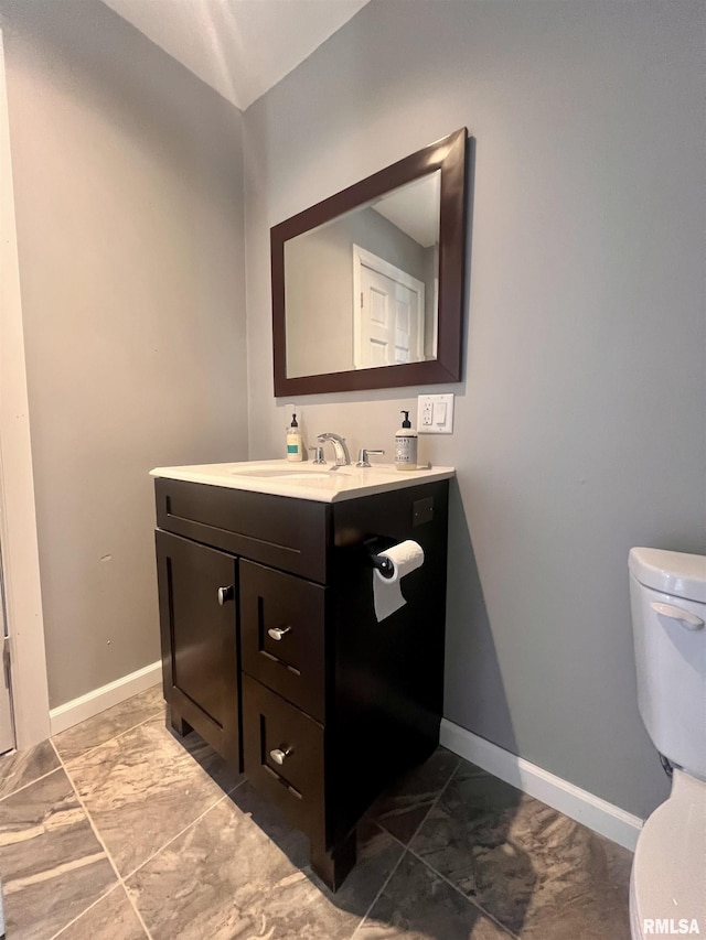 bathroom with marble finish floor, baseboards, vanity, and toilet