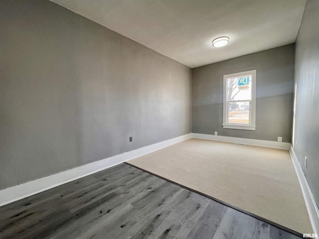 unfurnished room with wood finished floors and baseboards