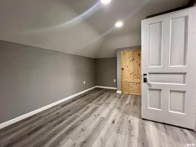 additional living space with lofted ceiling, wood finished floors, and baseboards