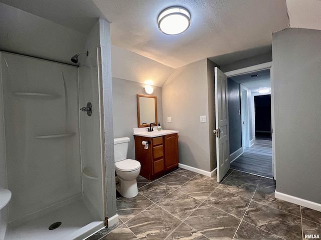 bathroom featuring baseboards, toilet, vaulted ceiling, vanity, and a shower stall