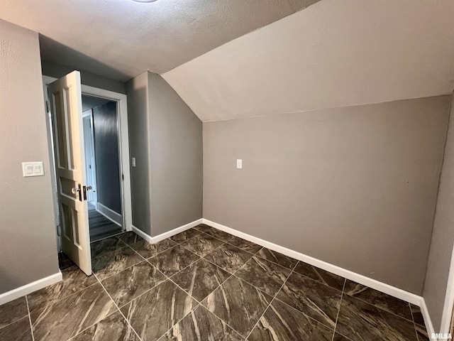 additional living space featuring vaulted ceiling and baseboards