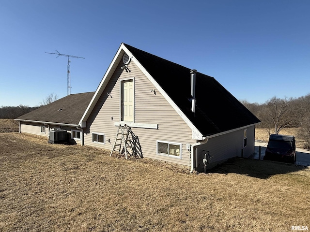 view of side of property featuring central AC and a yard