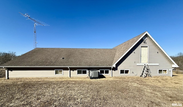 rear view of house with roof with shingles and cooling unit