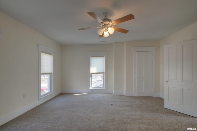 unfurnished room with carpet flooring, plenty of natural light, visible vents, and baseboards