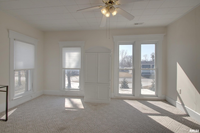 unfurnished living room featuring ceiling fan, carpet floors, visible vents, and baseboards