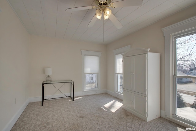 unfurnished room with light colored carpet, ceiling fan, and baseboards