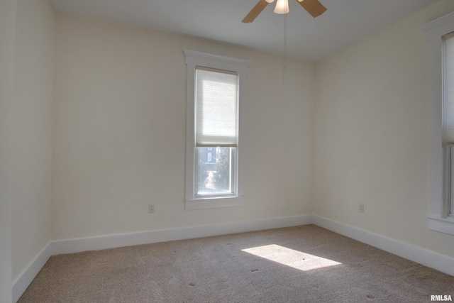 spare room with light carpet, ceiling fan, and baseboards