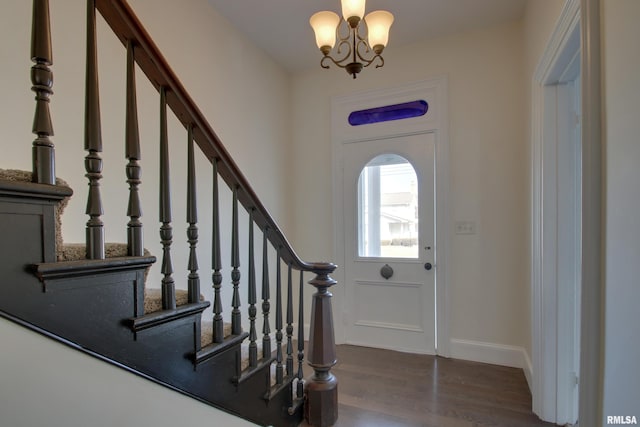 foyer with a chandelier, stairs, baseboards, and wood finished floors