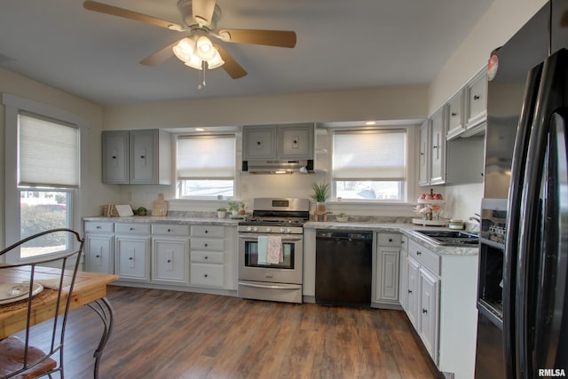 kitchen featuring dark wood-style floors, a sink, ceiling fan, under cabinet range hood, and black appliances