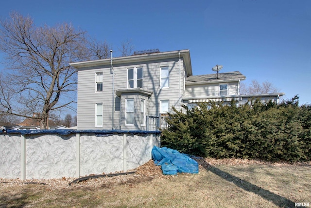 rear view of house with a covered pool