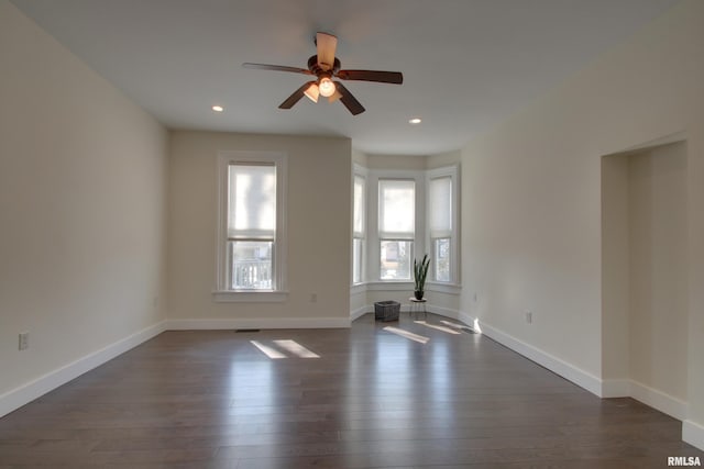 unfurnished room with recessed lighting, dark wood finished floors, a ceiling fan, and baseboards