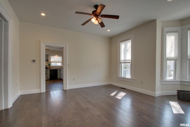 spare room featuring baseboards, visible vents, and dark wood-type flooring