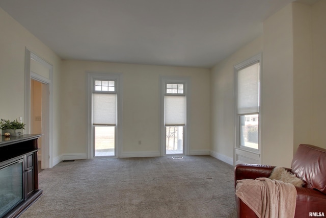 living room with baseboards and light colored carpet