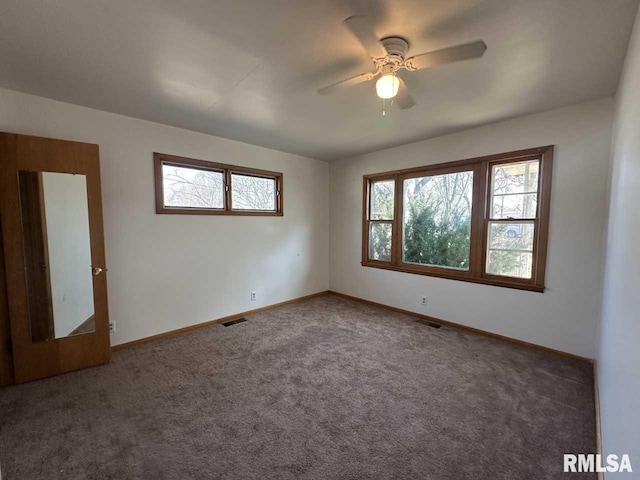 unfurnished room with carpet, visible vents, and a healthy amount of sunlight