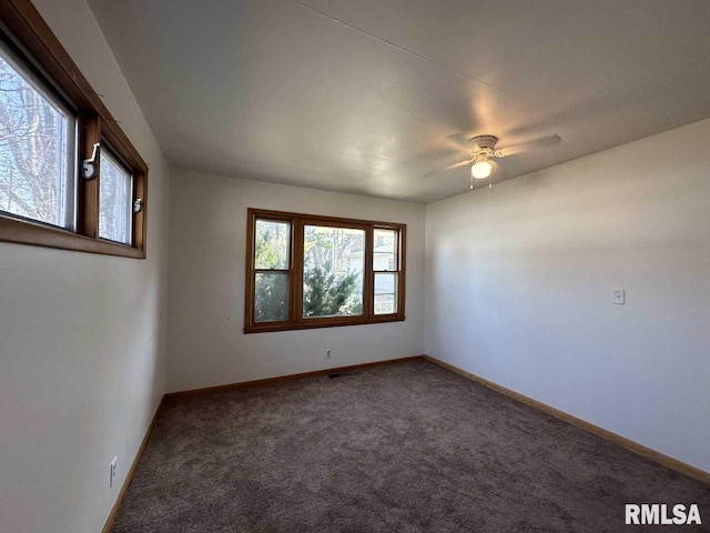 spare room with a ceiling fan, carpet flooring, and baseboards