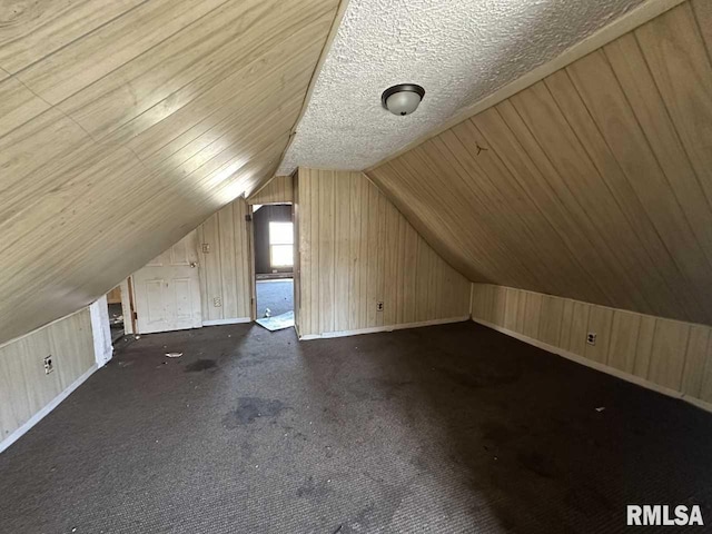 bonus room with carpet, wooden walls, and vaulted ceiling
