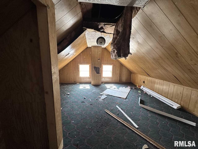 additional living space featuring lofted ceiling and wood walls