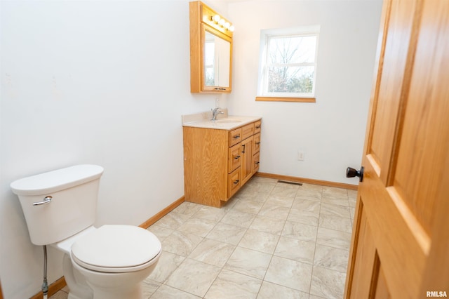 bathroom with visible vents, vanity, toilet, and baseboards
