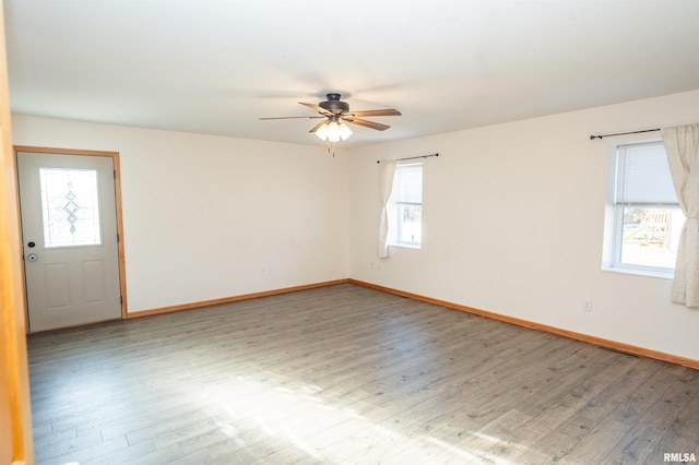 unfurnished room featuring ceiling fan, baseboards, and wood finished floors