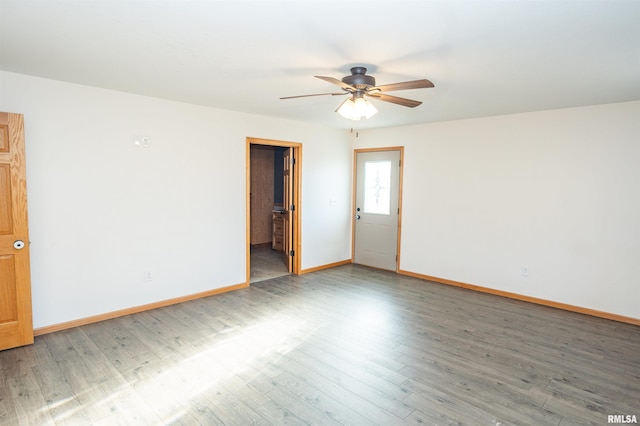 spare room featuring light wood-type flooring, ceiling fan, and baseboards