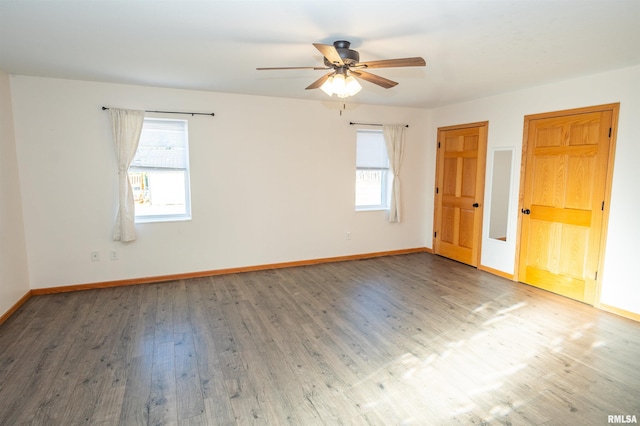 empty room featuring ceiling fan, baseboards, and wood finished floors