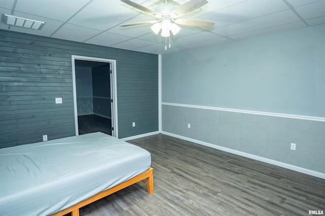 bedroom with a paneled ceiling, wood finished floors, visible vents, and a ceiling fan