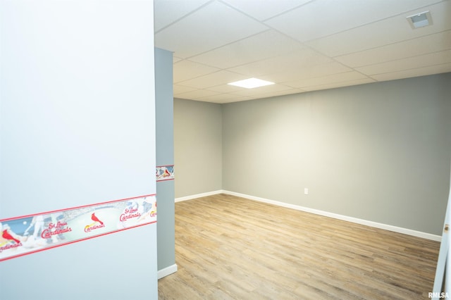 unfurnished room with visible vents, wood finished floors, a paneled ceiling, and baseboards