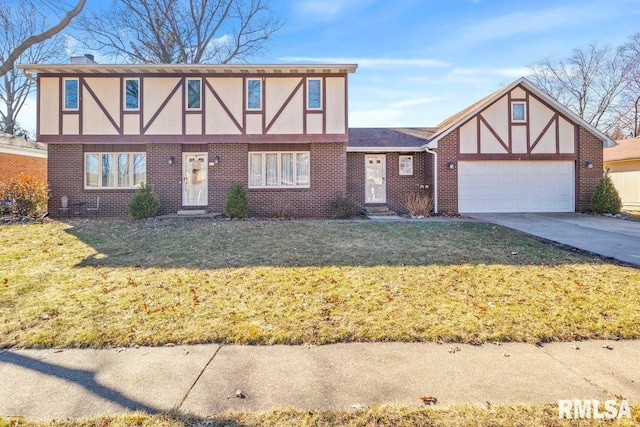 tudor home featuring brick siding, a chimney, a front yard, a garage, and driveway