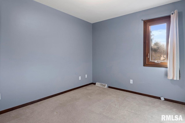 carpeted spare room with visible vents and baseboards